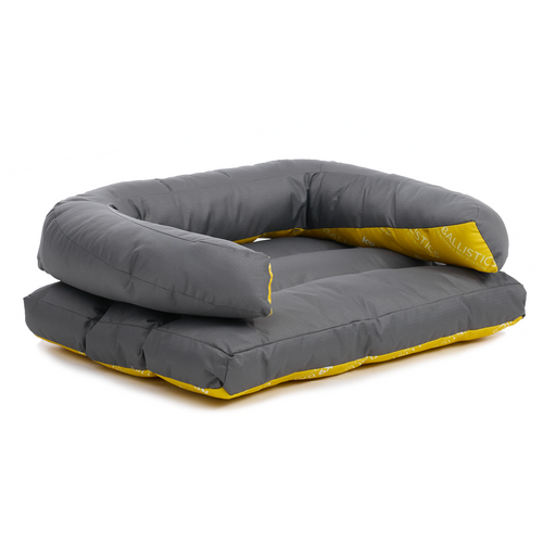 A gray and yellow U-shaped pillow sits atop a gray and yellow rectangle bed against a white background